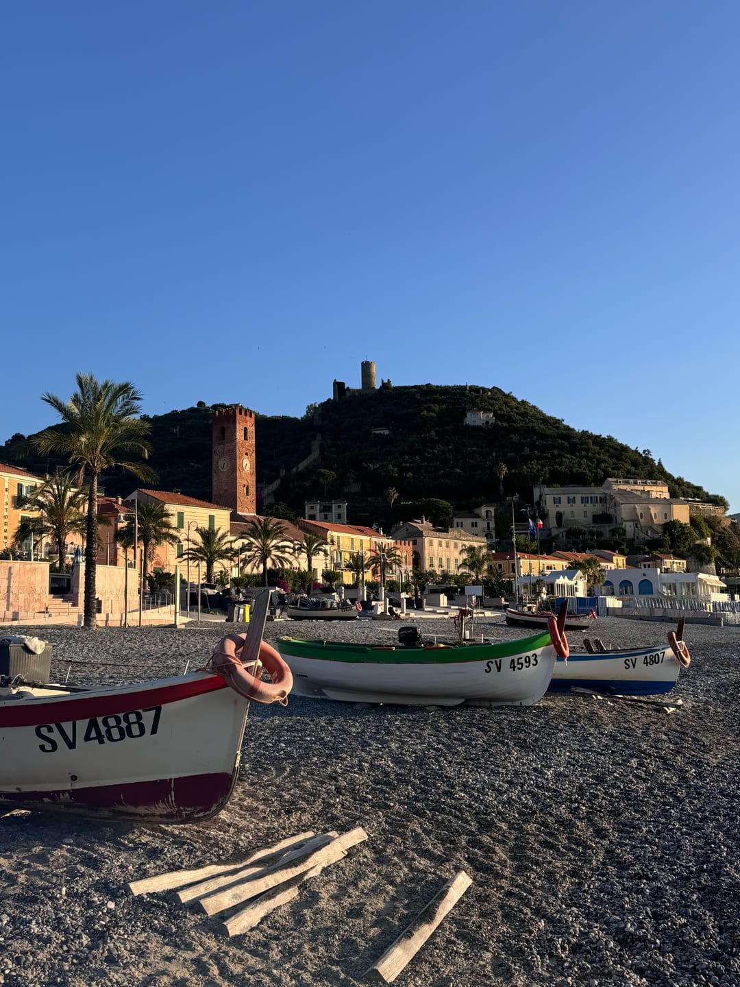 The beach of Noli — the wide beach of Noli on the bay, with the old town behind